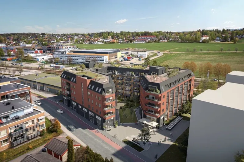 Brekkeveien 12–18: boligkvartal i rød tegl med mørke takoppbygg, sett ovenfra