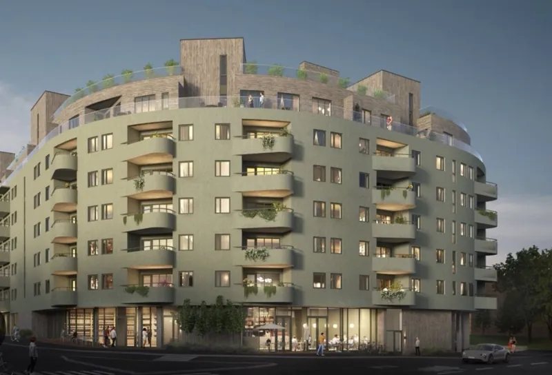 Fagerblom: boligbygg med grønn pusset fasade og avrundede balkonger i kveldslys