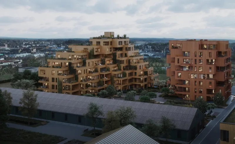 Magasinparken BB3: trappet boligbygg og høyhus med trefasader i skumringen
